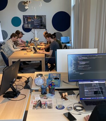 Ontwikkelaars aan het programmeren achter hun laptop op het kantoor van TrailBlazers tijdens de Hackaton van 11 januari 2025